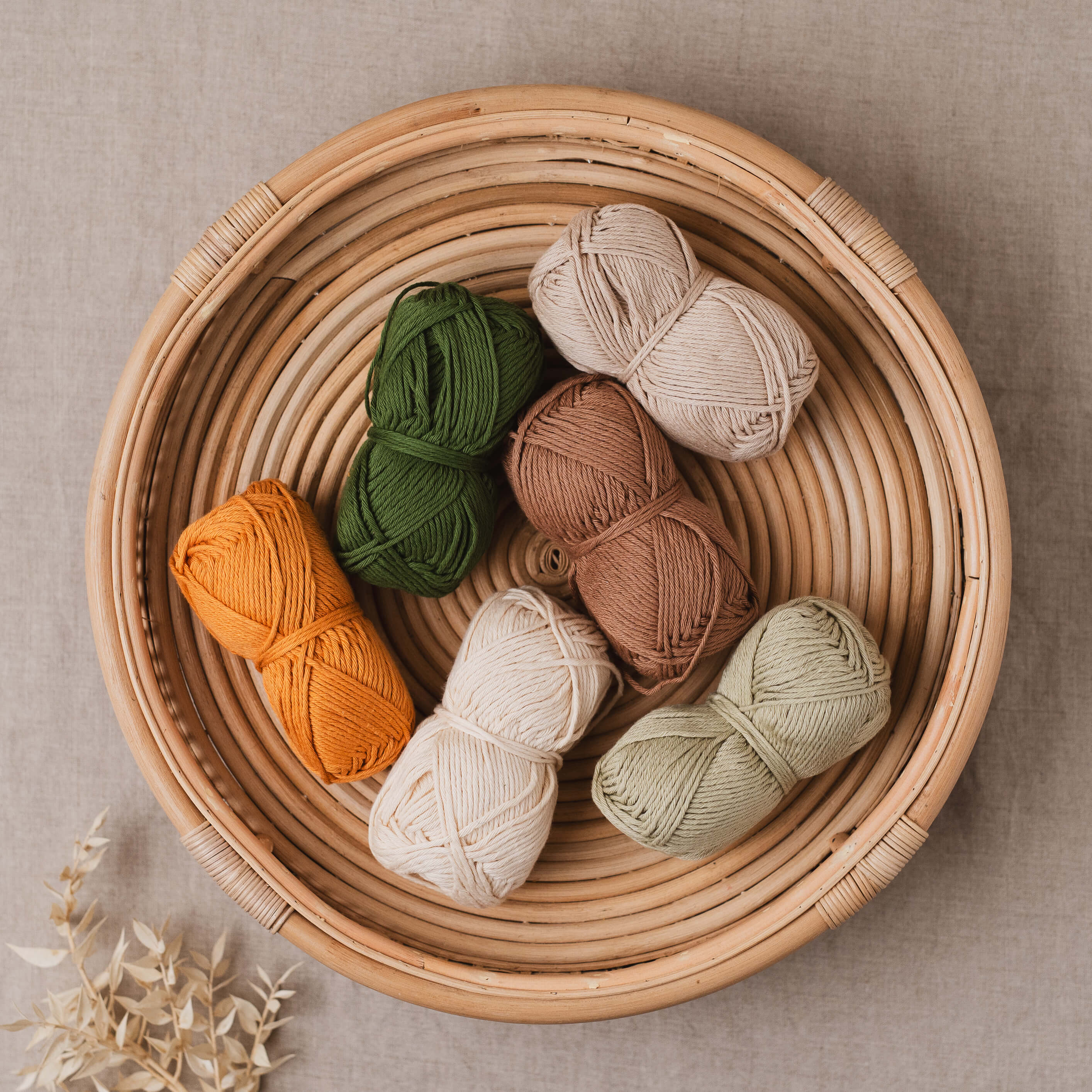 Earthy colour balls of cotton yarn in a bamboo basket