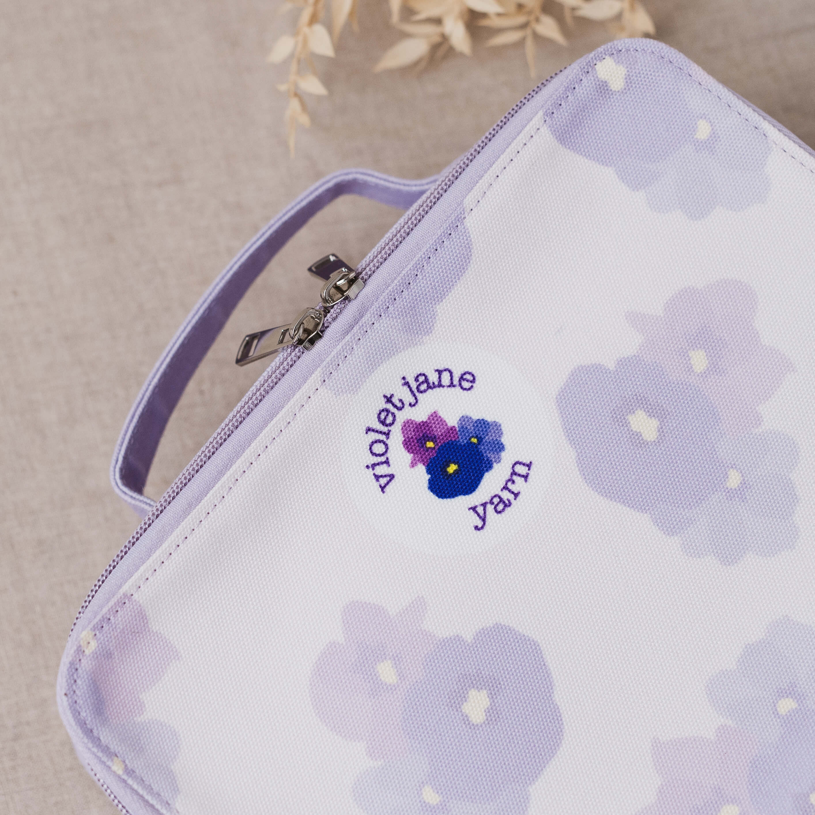 Zipper pouch with floral design and 'Violet Jane Yarn' branding on a beige background
