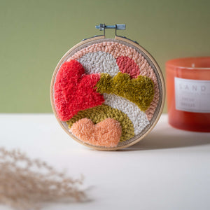 Dunes punch needle and tufted hoop in coral, white and chartreuse styled with dried flowers and a coral candle