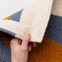 Load image into Gallery viewer, Hand folding over a punch needle rug