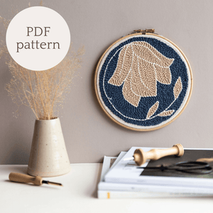 Autumnal floral punch needle hoop on a wall styled with dry flowers, text to indicate it is a PDF pattern