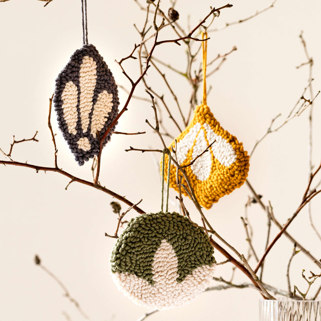 Classic punch needle bauble decorations handing from a twig tree