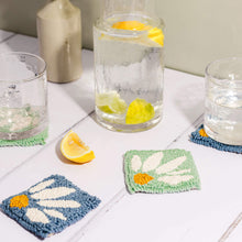 Load image into Gallery viewer, Punch needle coaster in blue and mint green, lemon water in a jug with glasses atop the coasters. A slice of lemon lies in the foreground.