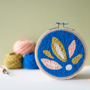 Summer leaves punch needle hoop with yarn and punch needle in the background