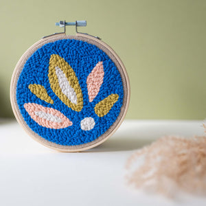 Summer leaves punch needle hoop in electric blue, peach, white and chartreuse with dried flowers in the foreground