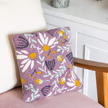 Load image into Gallery viewer, Lilac punch needle floral cushion propped against a pink velvet chair with a light cream cushion